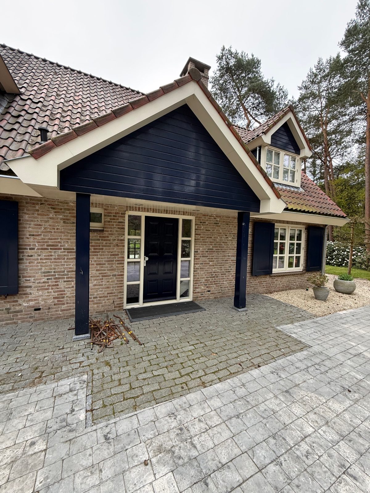 Bakstenen woning met witte ramen en donkere gevelbekleding